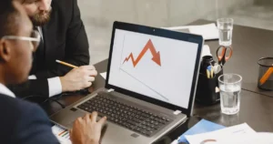 Colleagues in a meeting looking at a chart depicting declining business performance and market trends